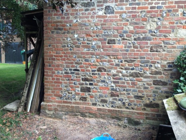 Repaired lime, brick and flint wall 