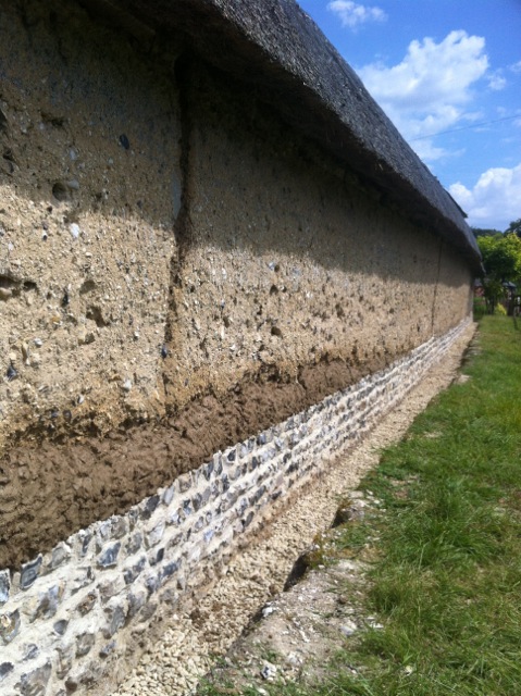 Rebuilt flint plinth with cob repair