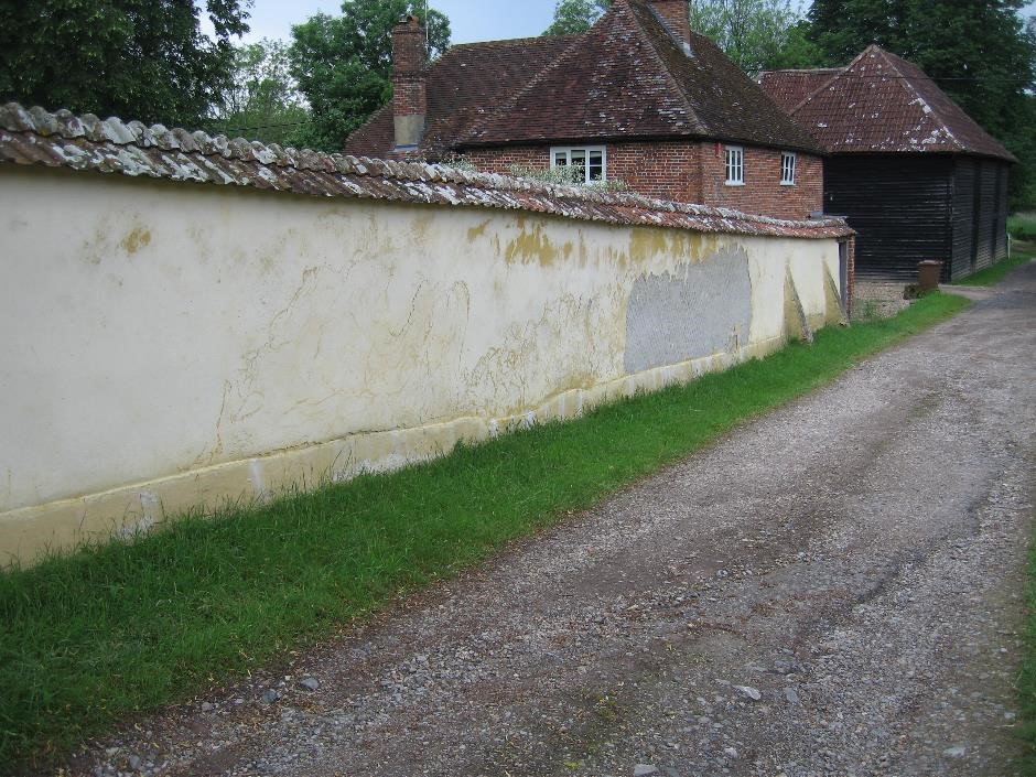 Flaking and leaning cob wall